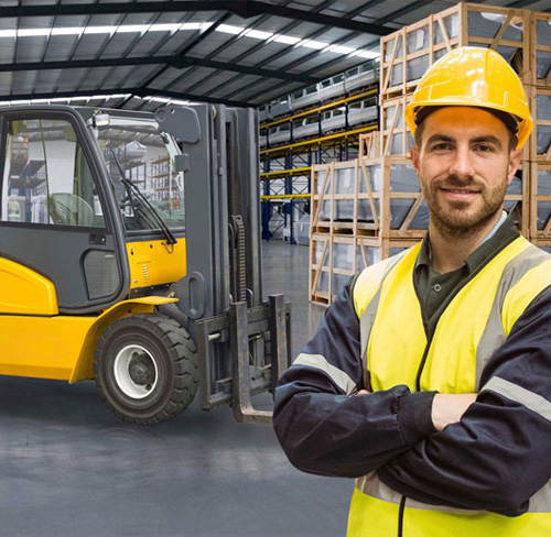 Operario de almacén al lado de una carretilla posando