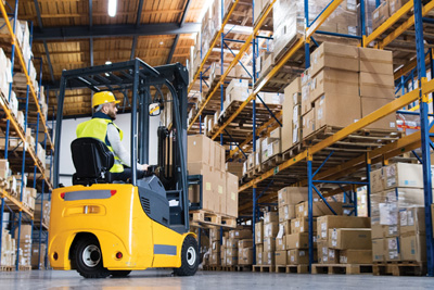 Operario en almacén trasladando mercancía. 